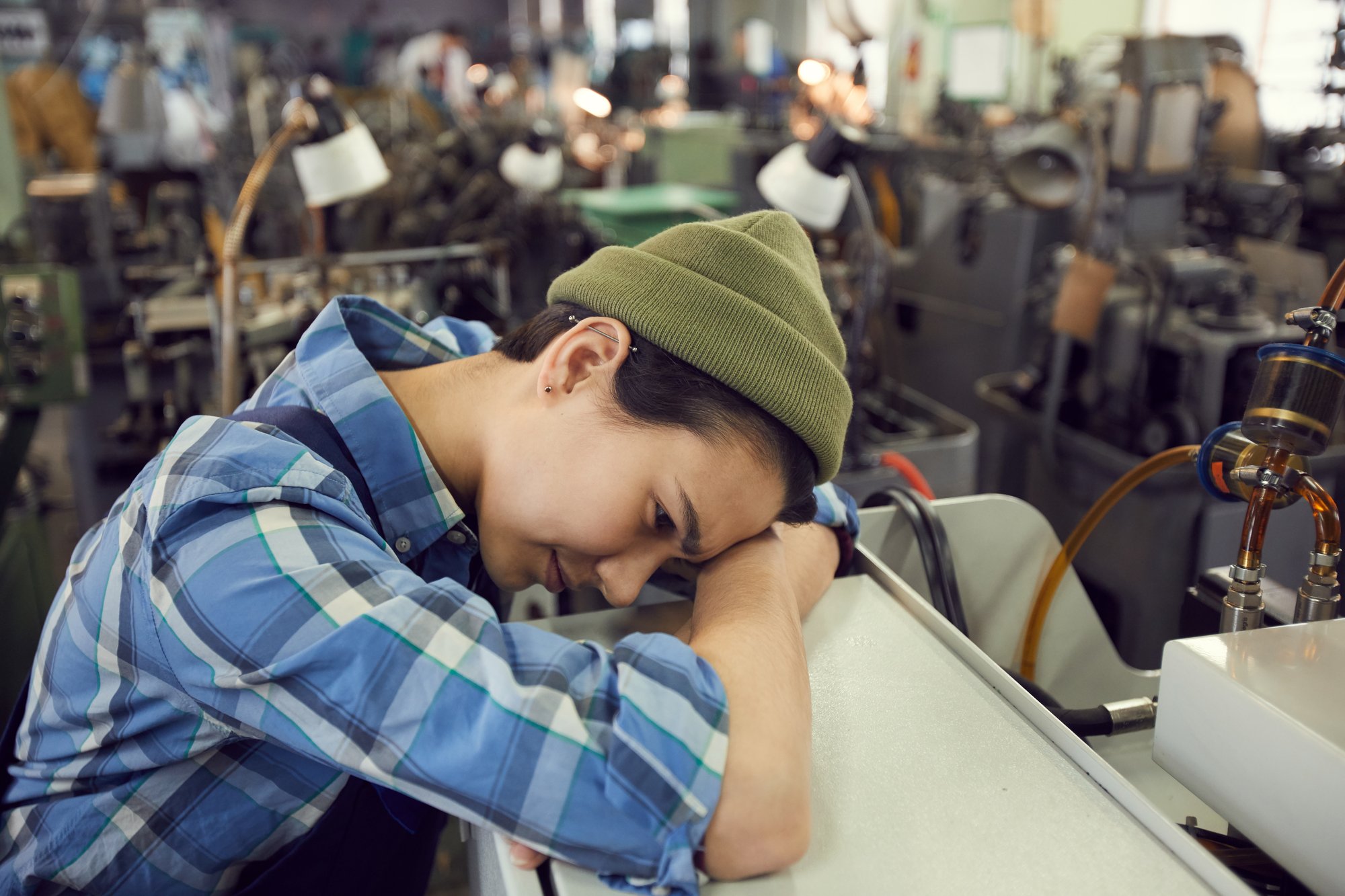 Fatigued production worker on mandatory overtime, a hidden cost of unfilled manufacturing jobs Fatigued production worker on mandatory overtime, a hidden cost of unfilled manufacturing jobs