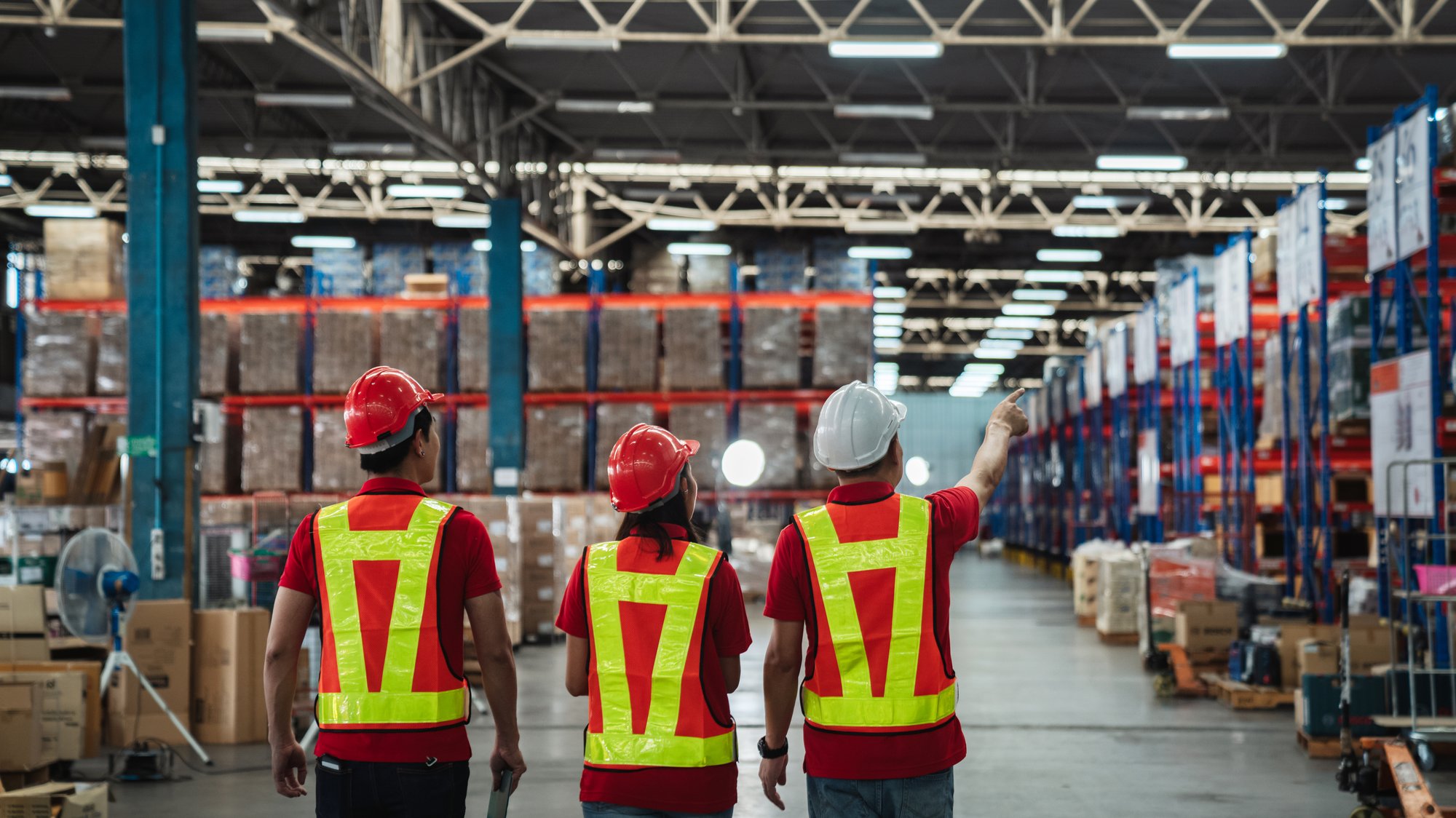 Warehouse workers walking to check details stock product in the background warehouse.