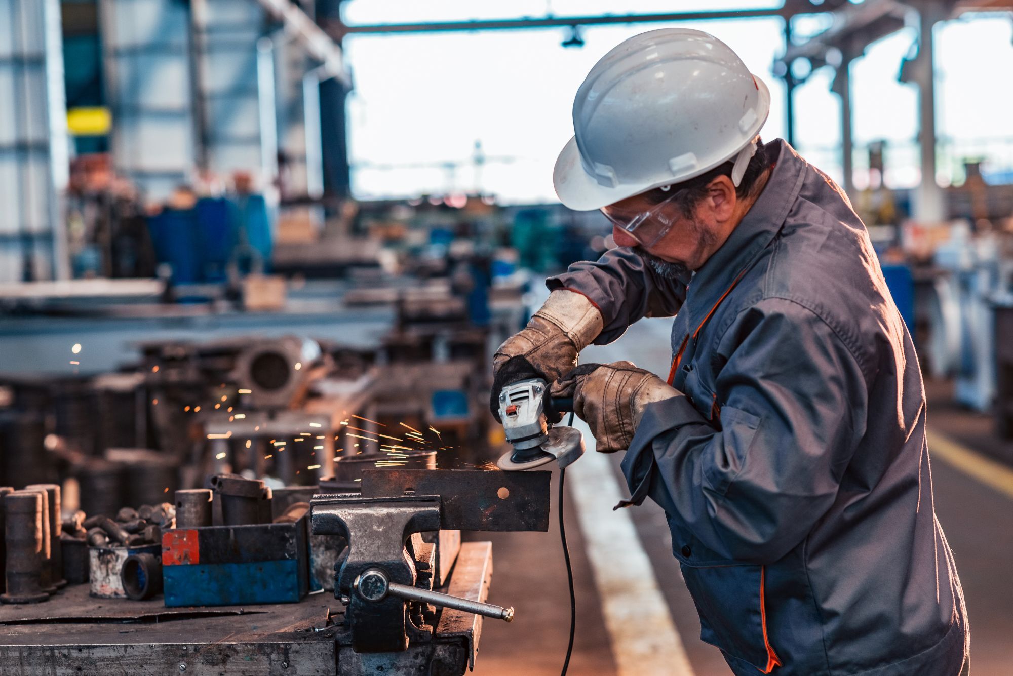 Skilled worker using an angle grinder in a workshop